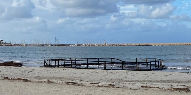 Mareggiata su Alghero, gabbia in spiaggia